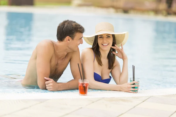 Pareja joven junto a la piscina — Foto de Stock