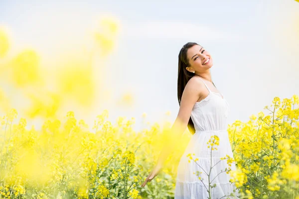 Ung kvinna i fältet under våren — Stockfoto