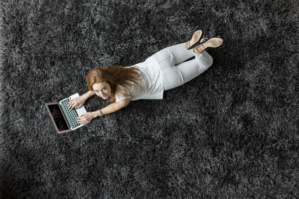 Woman laying on the carpet — Stock Photo, Image
