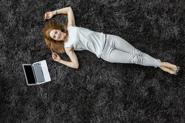 Женщина, лежащая на ковре — стоковое фото