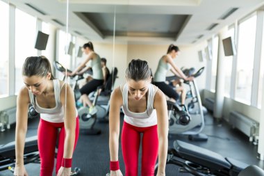 Spor salonunda çalışan genç bir kadın.