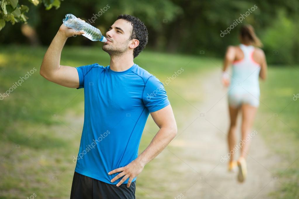 Можно пить воду стоя. Человек пьет воду. Спортсмен пьет воду. Парень пьет воду спортсмен. Водный человек.