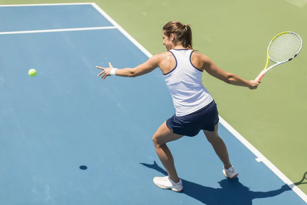 Jovem mulher jogando tênis — Fotografia de Stock