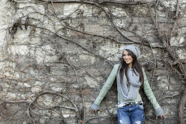 Mujer joven junto a la pared — Foto de Stock