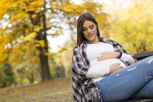 Femme enceinte assise dans le parc — Photo