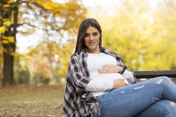 Mujer embarazada sentada en el parque — Foto de Stock