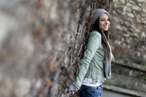 Jonge vrouw door de muur — Stockfoto