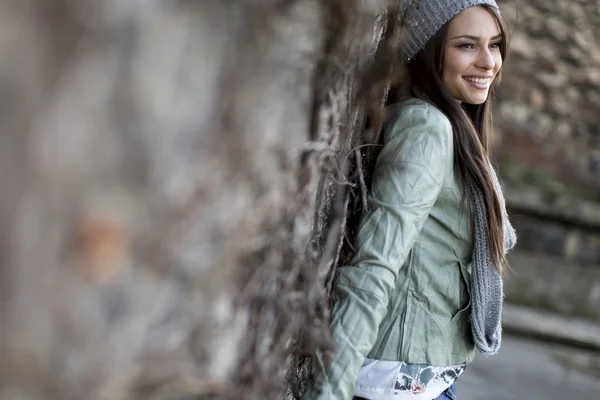 Jonge vrouw door de muur — Stockfoto