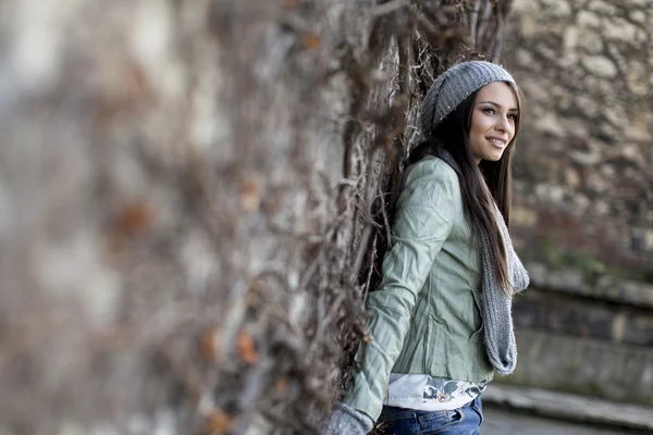 Frau im Herbst an der Wand — Stockfoto