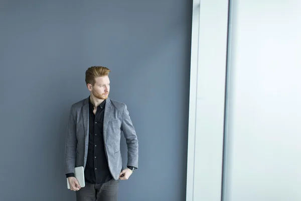 Man with tablet by the wall — Stock Photo, Image