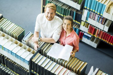 Genç kadın ve adam kütüphanede