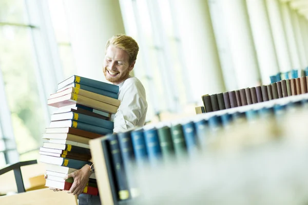 Mladý muž v knihovně — Stock fotografie