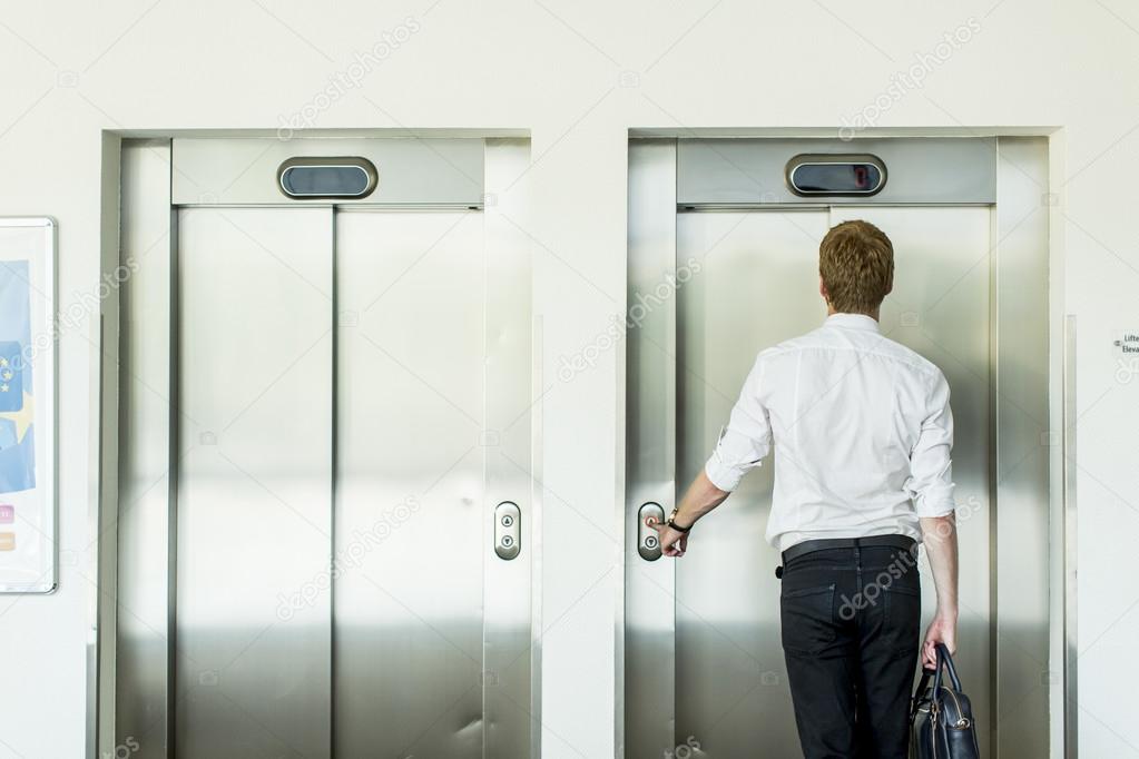 Young businessman in front of  elevator
