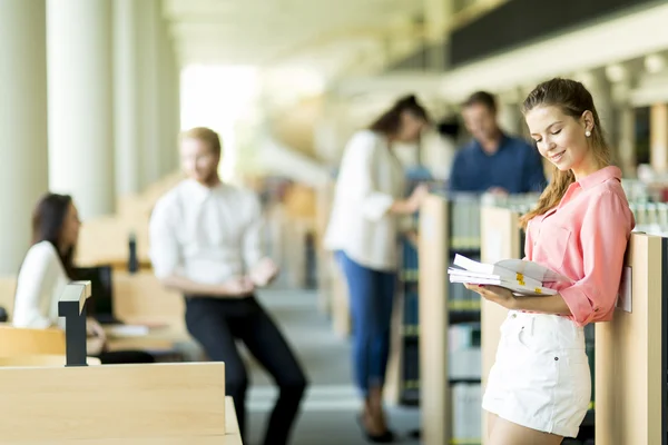 Ung kvinna i biblioteket — Stockfoto