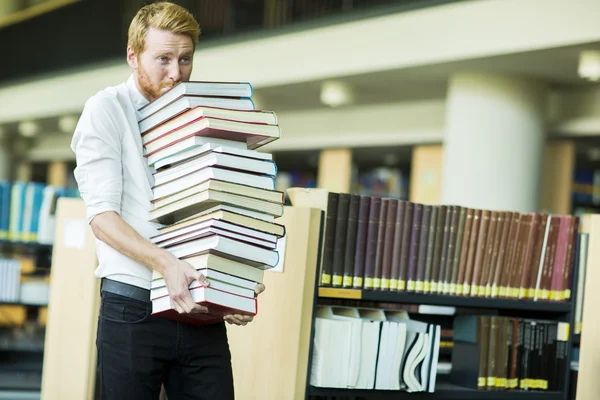 Młody człowiek w bibliotece — Zdjęcie stockowe