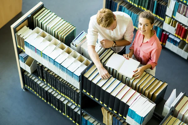 Kvinna och man i biblioteket — Stockfoto