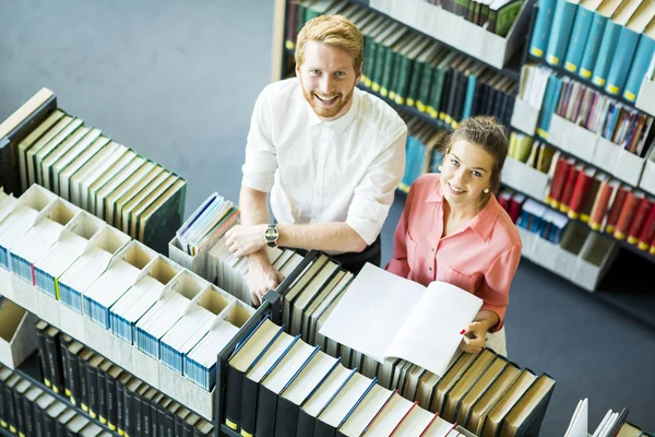 Woman and man in the library — Stock Photo, Image