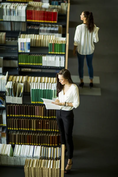 Jovens mulheres na biblioteca — Fotografia de Stock