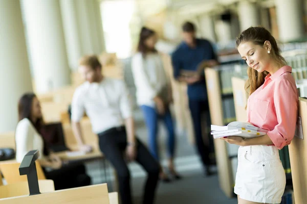 Ung kvinna i biblioteket — Stockfoto