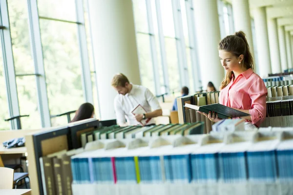 Ung kvinna i biblioteket — Stockfoto