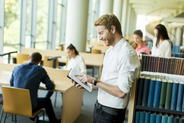 Młody człowiek w bibliotece — Zdjęcie stockowe