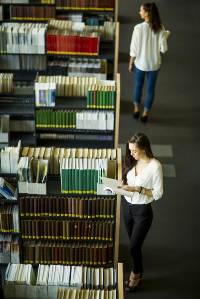 Unga kvinnor i biblioteket — Stockfoto