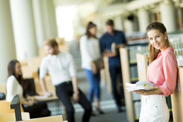 Ung kvinna i biblioteket — Stockfoto