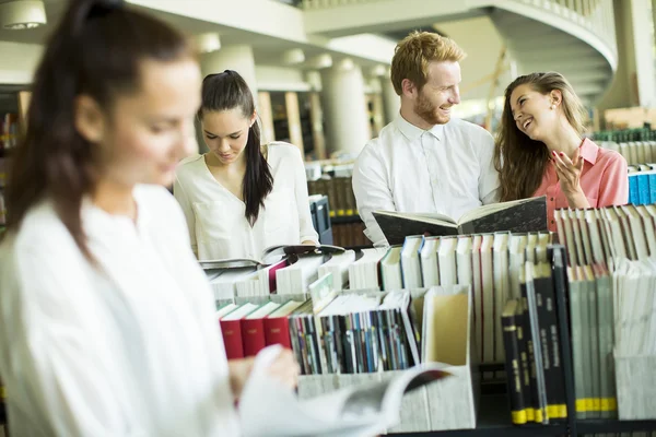 Studenti con libri in biblioteca — Foto Stock