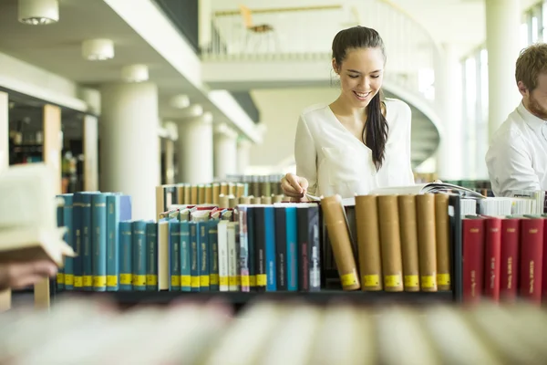 Ung kvinna i biblioteket — Stockfoto