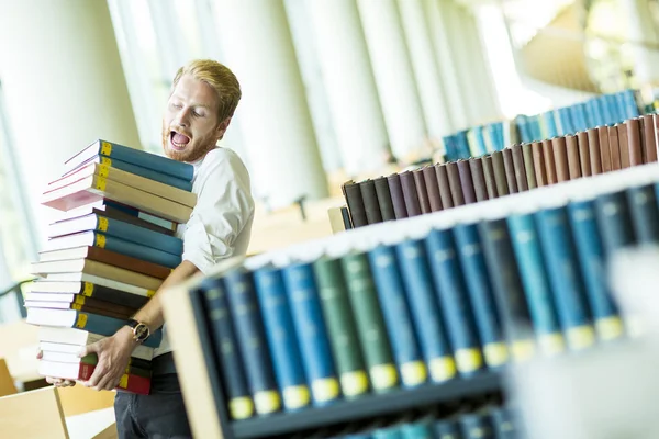 Młody człowiek w bibliotece — Zdjęcie stockowe