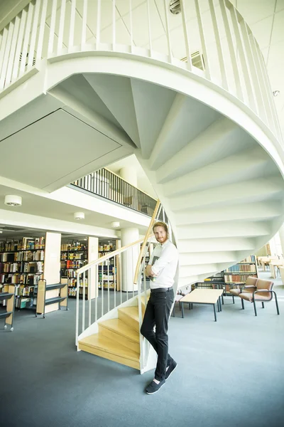 Young man in the library — Stock Photo, Image