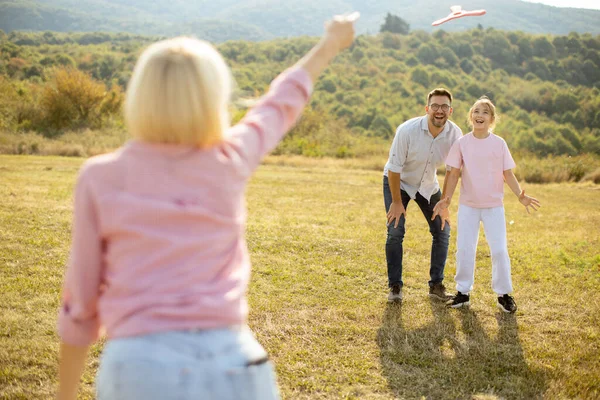 Bir aile öğleden sonra çimenli bir arazide eğlenirken, bir kadın çocukken oyuncak bir uçak fırlatıyor ve erkek manzarada heyecanla izliyor..