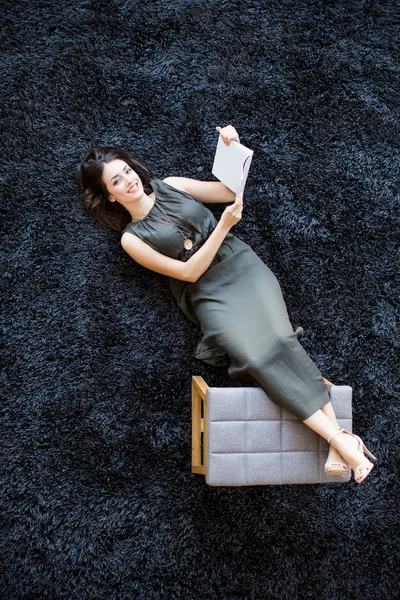 Donna con libro sul pavimento — Foto Stock