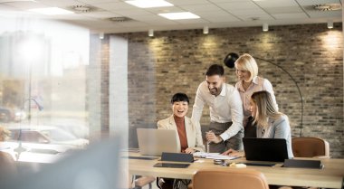 Çağdaş bir ofiste, dört profesyonel bir dizüstü bilgisayarın etrafında canlı bir tartışmaya girişir. Fikirlerini paylaştıkça ve bir proje üzerinde işbirliği yaptıklarında, odaklanmış ifadeleri takım çalışmasını gösteriyor..