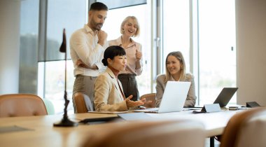 Çağdaş bir ofis ortamında çeşitli profesyonellerden oluşan bir grup toplantıya katılıyor. Öğlen ışığında dizüstü bilgisayarlardaki materyalleri incelerken fikirleri tartışıyorlar..