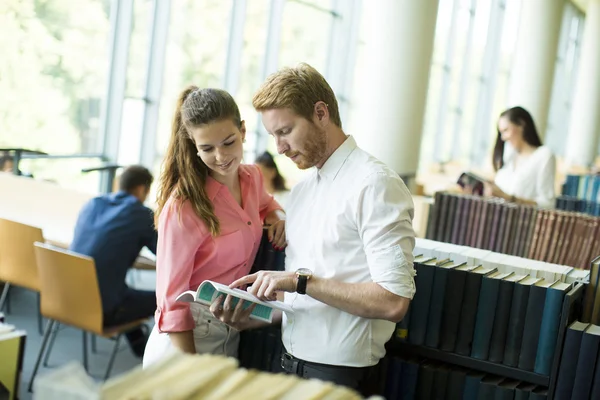 Young couple in the library — Stock Photo, Image