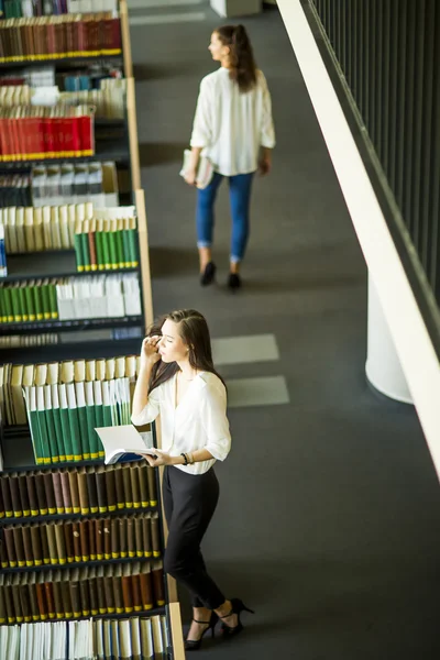 Jovens mulheres na biblioteca — Fotografia de Stock