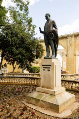 Gerald Strickland 'ın uzun heykeli Yukarı Barrakka Bahçelerinde gururla duruyor, yemyeşil ve canlı çiçeklerin arasında..
