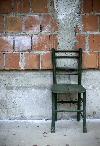 Старый стул у стены — стоковое фото