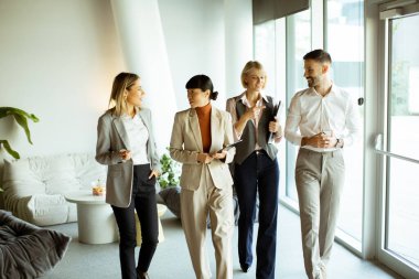 Farklı geçmişlere sahip dört profesyonel çağdaş bir ofis ortamında yürürken canlı bir sohbete girişiyor. Atmosfer işbirlikçi ve ilgi çekici..