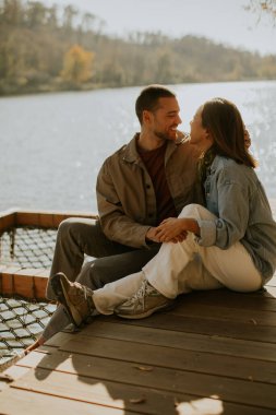Bir çift, deniz kenarında, doğayla iç içe, huzurlu bir öğleden sonranın tadını çıkarıyor..