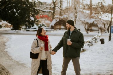Koreli bir kadın ve beyaz bir adam karlı bir parkta el ele yürüyorlar. İkisi de içki içip birbirlerine gülümsüyor. Kış mevsimindeyiz ve etrafımız karla kaplı..