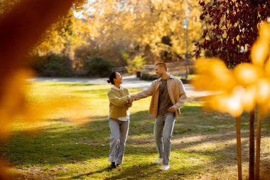 Parlak sonbahar yaprakları neşeli Koreli bir kadınla Kafkasyalı bir adamı çevreleyecek ve canlı bir parkta el ele dolaşacaklar..