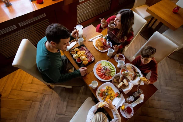 Herkes, sıcacık bir restoran ortamında, kahkahaları ve lezzetli yemekleri paylaşarak, sağlıklı bir kahvaltıdan zevk alır..