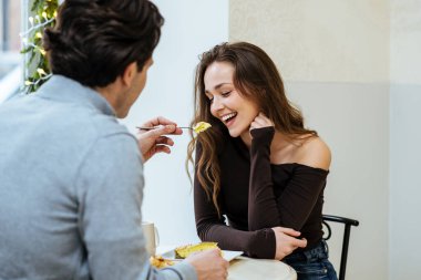 İki arkadaş bir kafede tatlıyı paylaşır. Bir adam gülümseyen bir kadına yemek sunar. Bir masada oturuyorlar, güneşli bir öğleden sonra birlikte vakit geçiriyorlar..