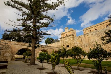 Ziyaretçiler, yemyeşil ve antik taş duvarlarla çevrili etkileyici Mdina Kapısı 'na hayran kalarak, Malta' nın Sessiz Şehri 'nin güzelliğini gözler önüne seriyor..