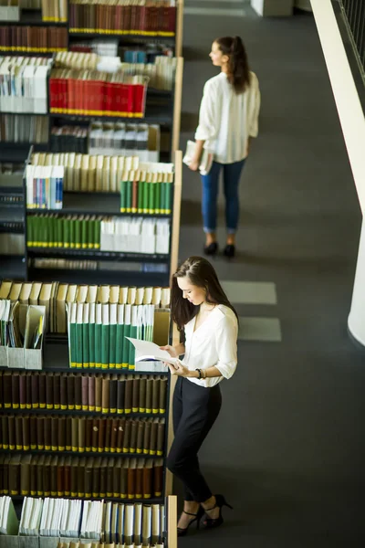 Fiatal nők a könyvtárban — Stock Fotó