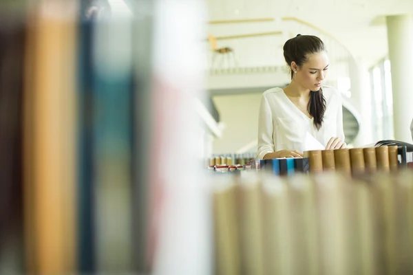 Młoda kobieta w bibliotece — Zdjęcie stockowe