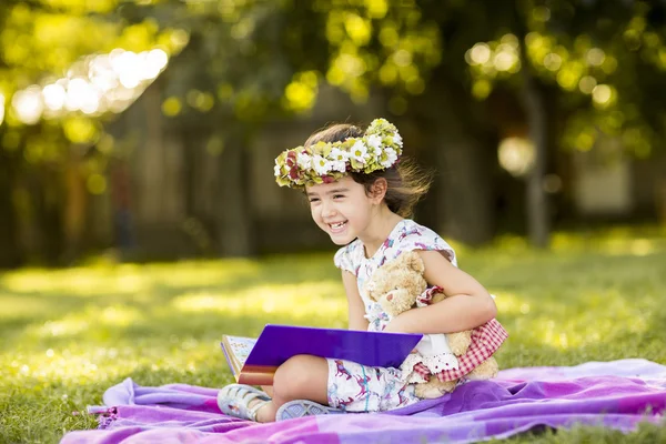 Bambina che legge nel parco — Foto Stock