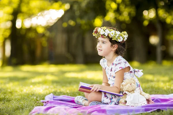 Bambina che legge nel parco — Foto Stock